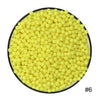 A pile of bright yellow water beads, numbered #6, is displayed in a black bowl.
