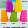 Five colored plastic cups in purple, yellow, orange, green, and pink arranged in a vertical stack.