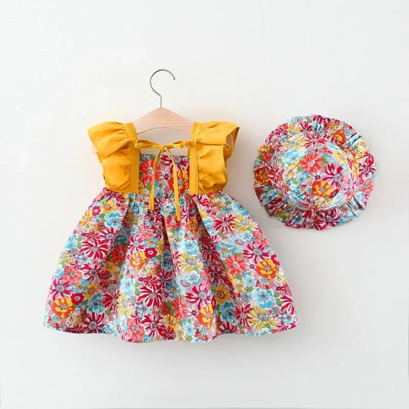 A yellow-sleeved floral print dress for a baby girl with a matching floral hat displayed on a hanger.