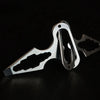 Stainless steel keychain multitool with bottle opener displayed on a dark surface.