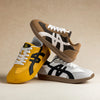 Paar klassische minimalistische Barfuß-Sneaker in Gelb und Beige auf hellem Hintergrund