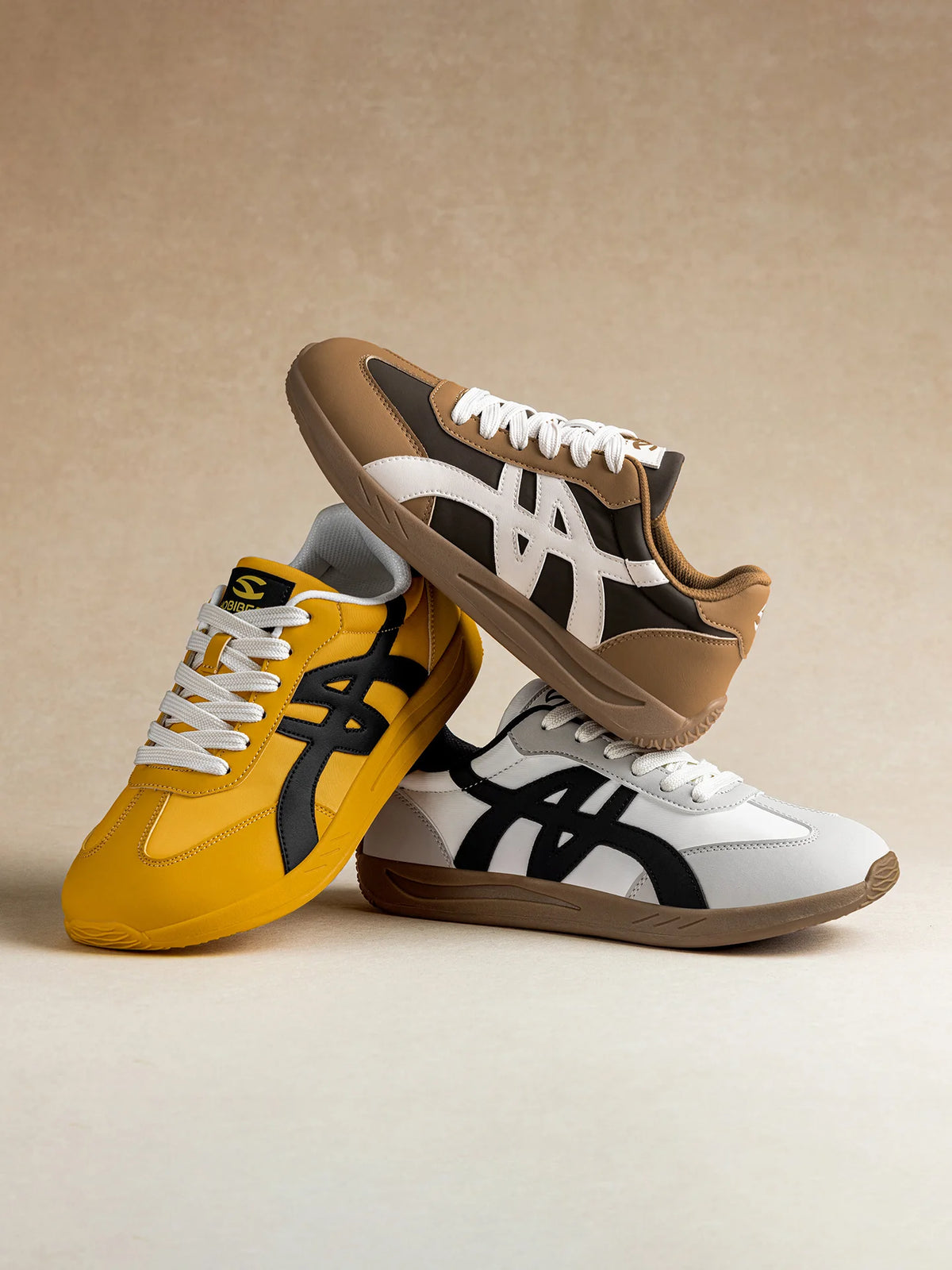 Paar klassische minimalistische Barfuß-Sneaker in Gelb und Beige auf hellem Hintergrund