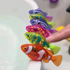 A hand is holding a brightly colored photosensitive robotic clownfish toy with vibrant orange and yellow hues.