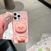 Sujetador magnético para teléfono en forma de cerdo rosa 3D, sostenido en una mano contra un fondo claro.