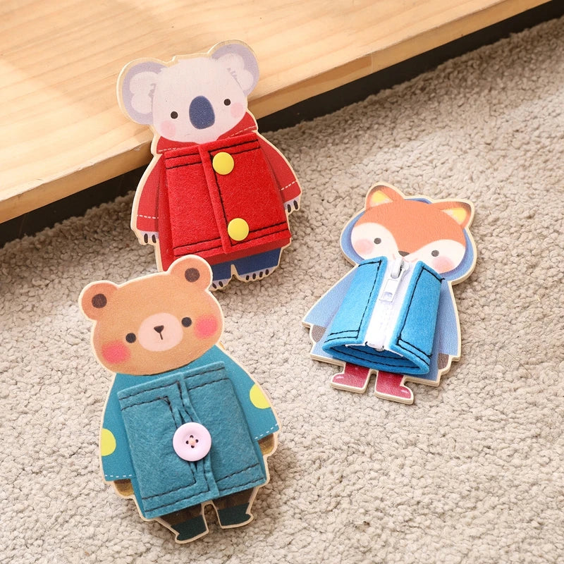 Two wooden Montessori busy board figures, one a bear in blue and yellow, and the other a fox in blue and white.