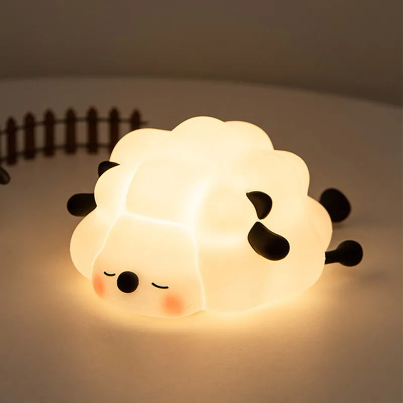 A glowing silicone rabbit touch night light with closed eyes and small ears resting on a surface.