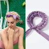 A close-up of a woman wearing a purple heatless curling rod headband, showing the product detail and styling.