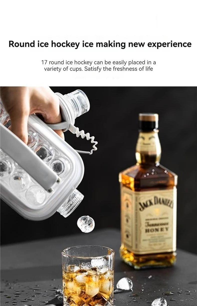 A hand is shown placing ice into a clear mold, next to a glass of iced honey and a bottle.