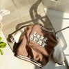 A brown fleece-lined corduroy jacket with a white bear graphic lying on a woven mat.