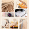 A collection of beige knit jacquard shawls and a portable heated electric blanket being used for warmth.