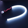 مصباح عمل LED من السيليكون المرن بمقبض أبيض وأسود ينحني على سطح داكن