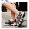 A close-up of a pair of navy blue boys' breathable summer sport sandals worn on a person's foot.