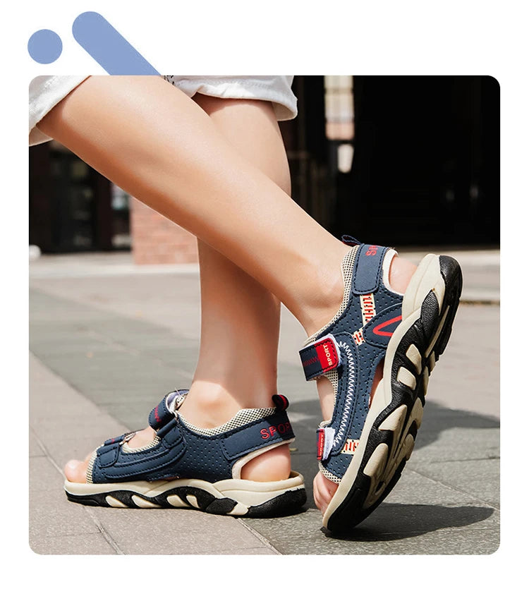 A close-up of a pair of navy blue boys' breathable summer sport sandals worn on a person's foot.