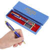 Una mano sostiene un bolígrafo conmemorativo azul y dorado en un estuche azul por el 250 aniversario de Estados Unidos.