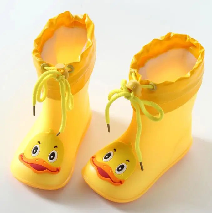 A pair of bright yellow kids' rain boots with yellow laces and duck-shaped feet.