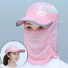 A close-up of a pink foldable UV protection sun hat with a fabric face cover worn by a woman.