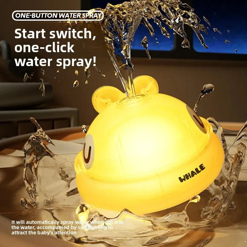 A yellow light-up whale bath toy is shown spraying water, designed to attract a baby's attention.