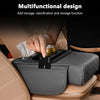 A hand places a black organizer with an armrest cushion and cup holder into a car center console.