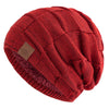A close-up of a red knit beanie with a multicolor pattern, shown at an angle.
