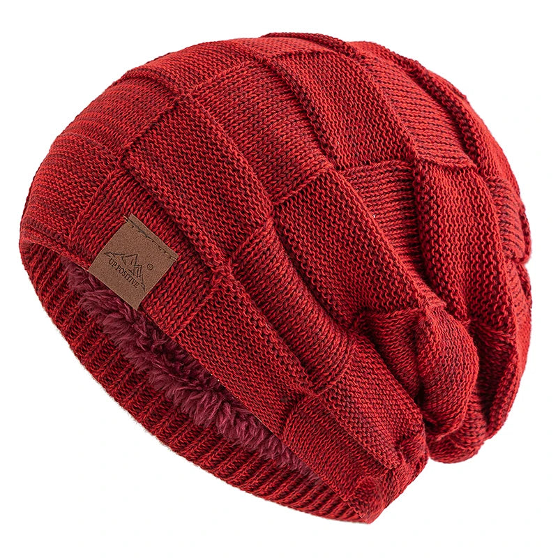 A close-up of a red knit beanie with a multicolor pattern, shown at an angle.