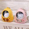 A pair of cute bear nightlight keychains in yellow and pink with astronaut charms resting on a white box.