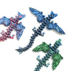Tres figuritas de dragón de escritorio articuladas impresas en 3D en colores azul y rojo.