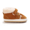 A pair of brown suede baby winter snow boots with a fluffy cream-colored shearling lining and white soles.