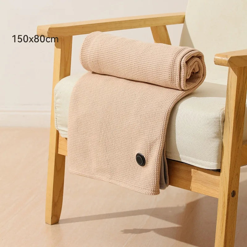 A beige knitted shawl or electric blanket draped over a wooden chair.