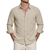 A man wearing a beige long sleeve button-down shirt and light colored pants.
