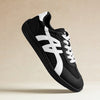 Minimalistischer Sneaker in Schwarz-Weiß im Seitenprofil vor neutralem Hintergrund