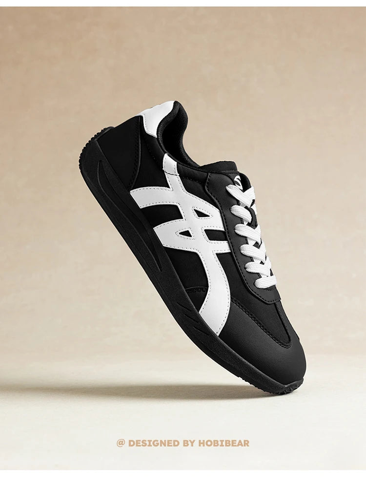 Minimalistischer Sneaker in Schwarz-Weiß im Seitenprofil vor neutralem Hintergrund