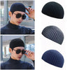 A black knitted beanie shown in various angles and worn by a model, featuring a ribbed texture.