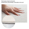 A hand is touching a thick, white, hypoallergenic rug with a dachshund shape.
