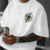 A man wearing a white Tiger Claw graphic cotton tee, showing off his tattooed arm.