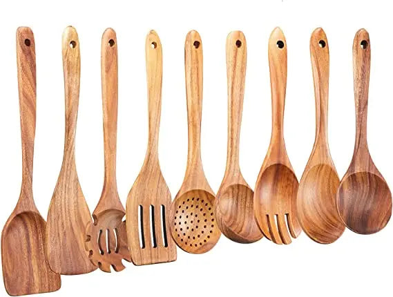 A set of natural teak wood cooking utensils including spatulas, forks, and spoons.