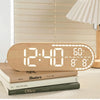 A light wood digital clock displaying 12:40, 60°F, and the day of the week, resting on a stack of books.