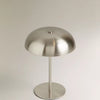 A modern, silver-toned portable touch table lamp with a dome shade and a cylindrical stand.