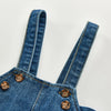 A close-up of a solid denim romper for babies and toddlers showing the collar and buttons.