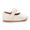 A pair of soft white baby first walker shoes with a decorative flower detail.