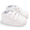 A pair of white soft sole baby pre-walker sneakers for infants shown from above.