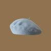 A light blue classic wool beret hat resting on a plain brown background.