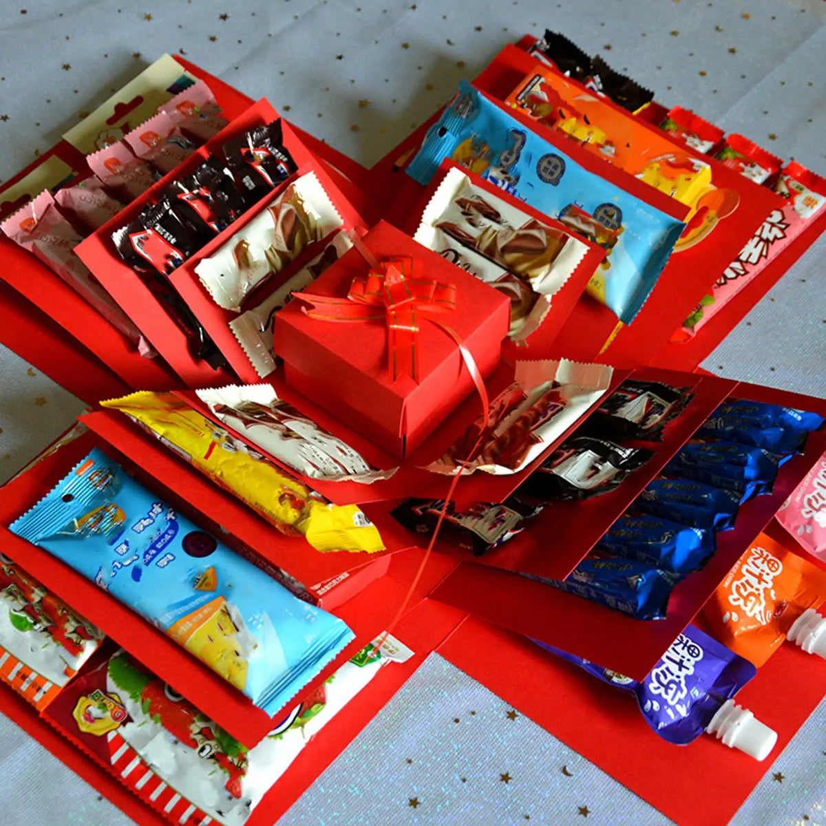 A collection of DIY explosion surprise gift box kits in various colors and designs packaged in red boxes.