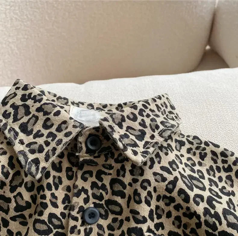 A close-up of a beige and black leopard print denim shirt worn casually.