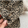 Close-up of a beige leopard print denim jacket sleeve showing the collar and cuff detail.