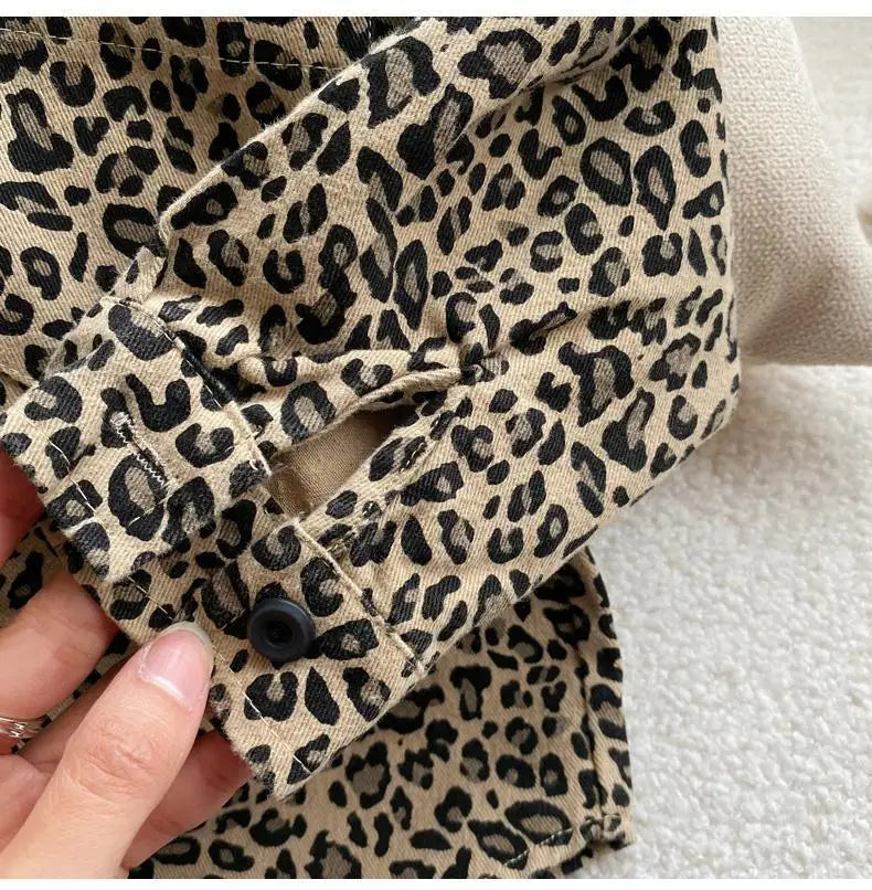 Close-up of a beige leopard print denim jacket sleeve showing the collar and cuff detail.