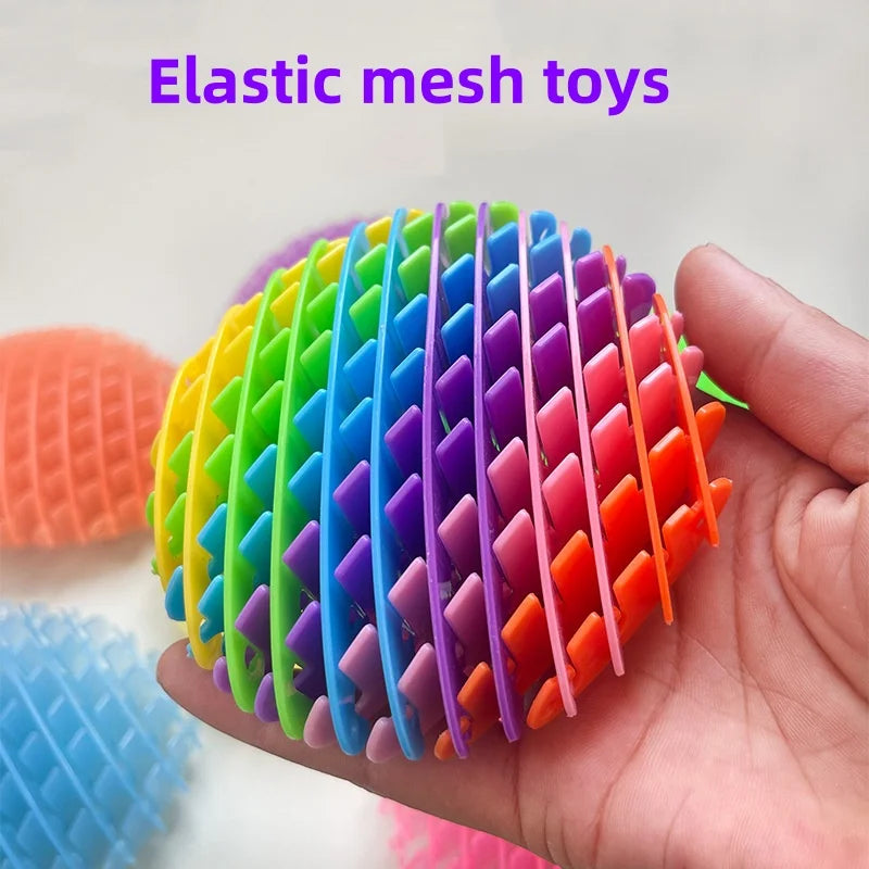 Una mano sostiene un juguete elástico de malla colorida con segmentos de plástico de colores.
