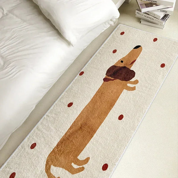 A long dachshund shaped cozy rug with reddish-brown dots lying on a white bed.