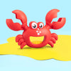 A bright red kids beach sand toy set featuring a crab and dinosaur claw tools resting on a yellow surface.