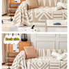 Beigefarbene und weiße Boho-Chenille-Tagesdecke mit Fransen auf hellem Sofa