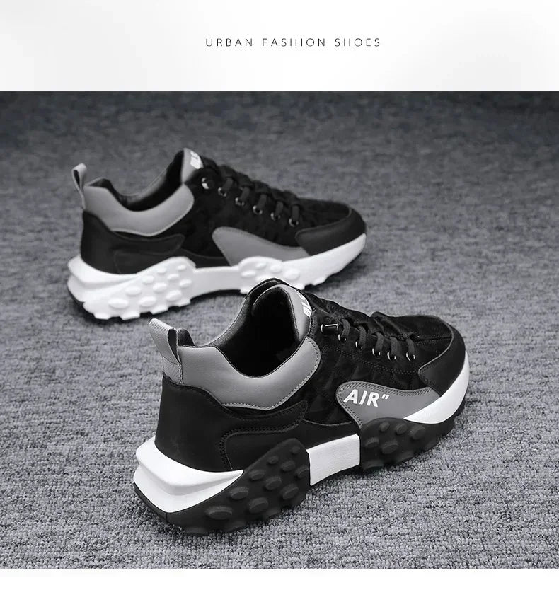 Une paire de baskets plateforme style Air Force noires et grises reposant sur une surface texturée grise.